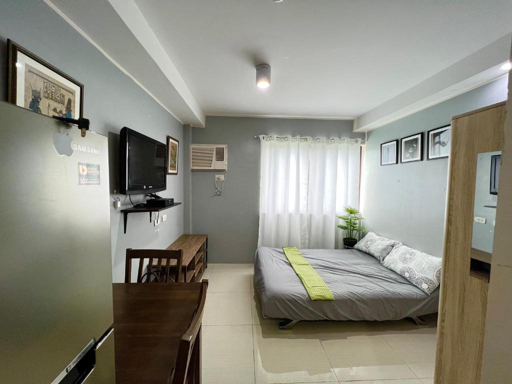 Cette petite chambre comprend un lit et une télévision. dans l'établissement CebuSureStay Persimmon Studio 535, à Cebu