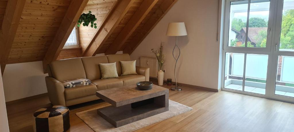 ein Wohnzimmer mit einem Sofa und einem Tisch in der Unterkunft Apartment am Ammersee in Herrsching am Ammersee