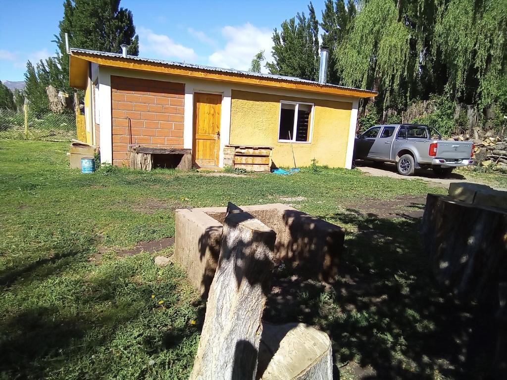 une petite maison avec une clôture devant dans l'établissement Cabaña los sauces, à Chile Chico