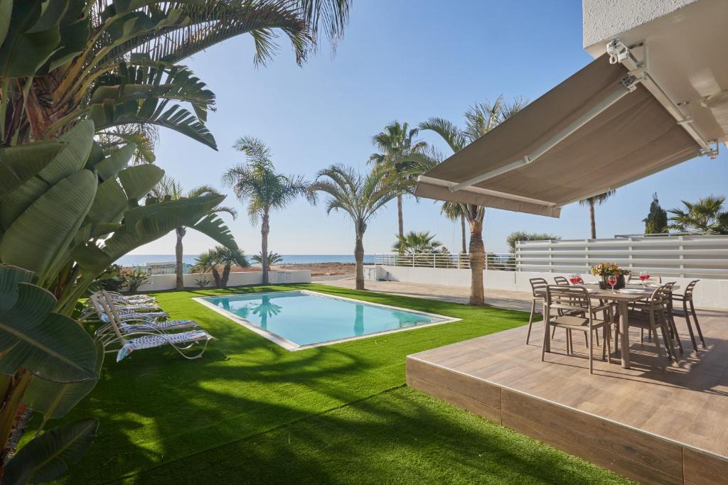 a backyard with a table and chairs and a swimming pool at Sunrise Villa 9 in Ayia Napa