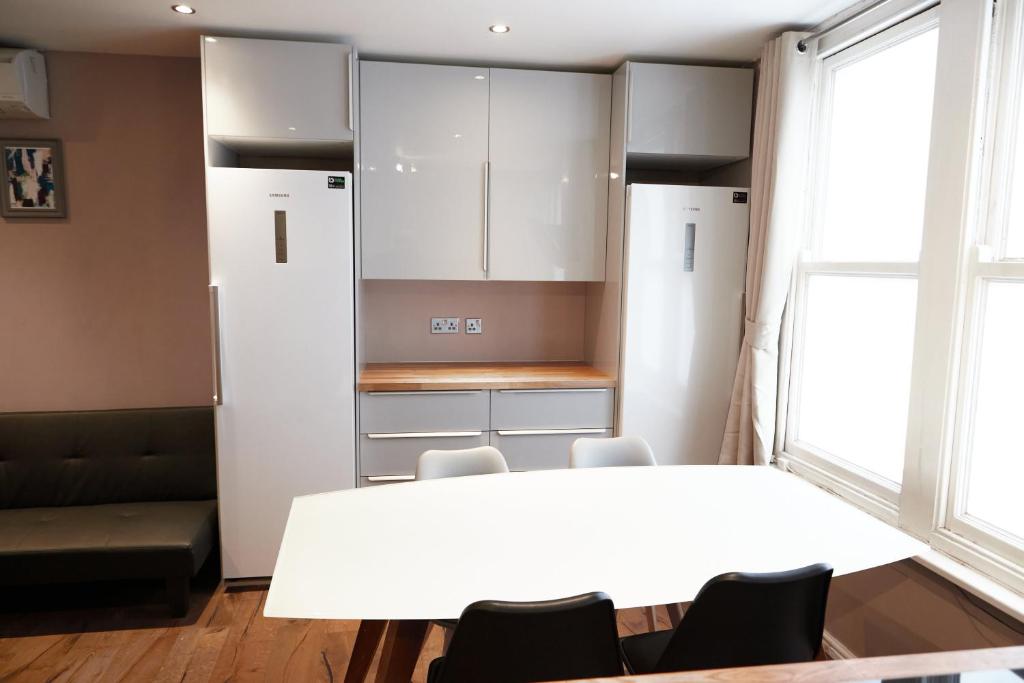 a dining room with a white table and chairs at Luxury Apartment located near Marble Arch & Baker Street in London