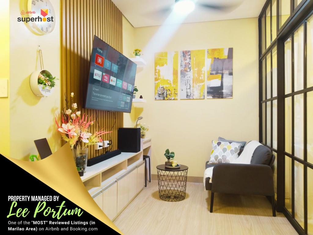 a living room with a tv and a couch and a chair at C516 Place at SMDC Cheer Residences by Lee Portum in Marilao