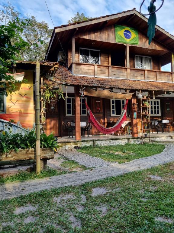 a wooden house with a flag on it at Pousada Sobre as Ondas - ILHA DO MEL - PR in Ilha do Mel