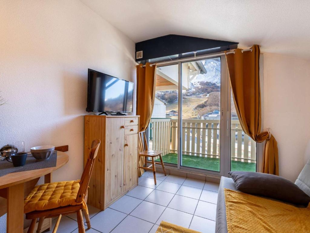 a living room with a television and a balcony at Appartement 4 pers cosy avec wifi et casier à skis, Vue pistes, Gourette - FR-1-400-123 in Eaux-Bonnes