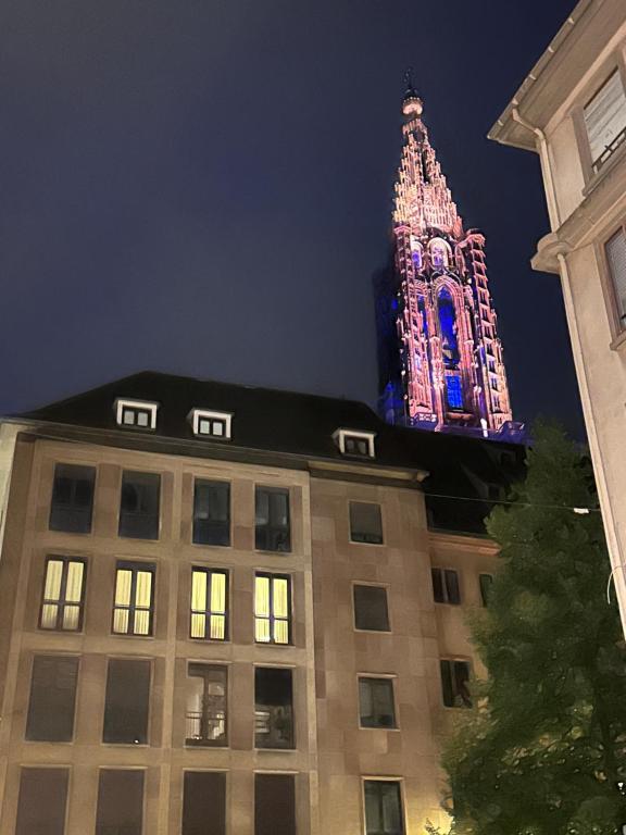 un edificio con una torre iluminada por la noche en Les toits de Gutenberg, en Estrasburgo