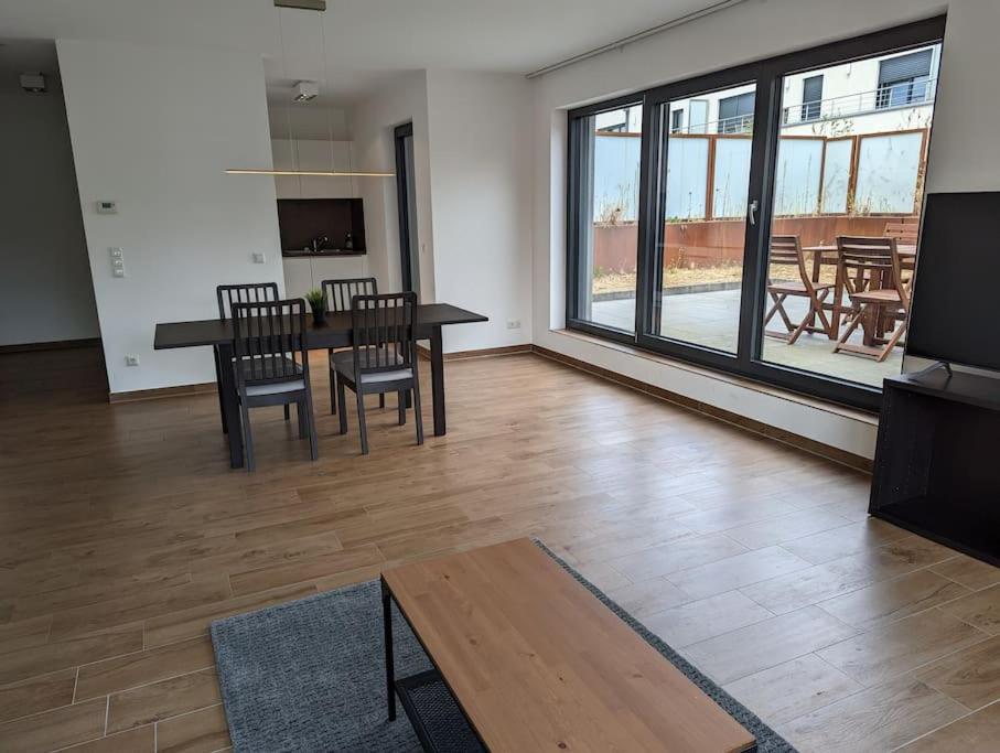 a living room with a table and chairs and a large window at 1 Bedroom Apartment with Garage & Outdoor Area in Kirchberg in Luxembourg