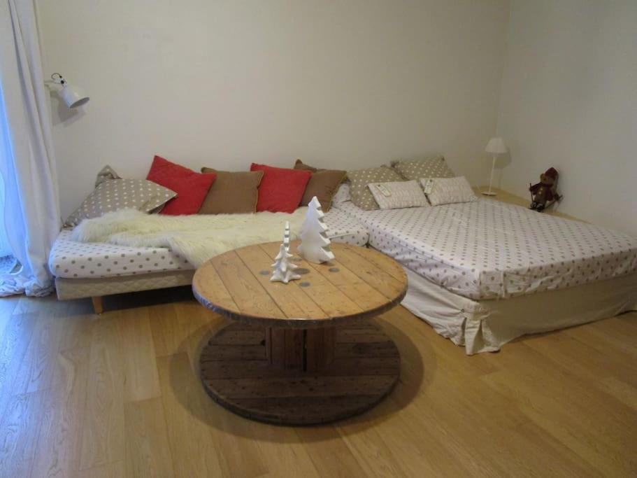 Sala de estar con 2 camas y mesa en L'ENVOLEE, en Champdeniers