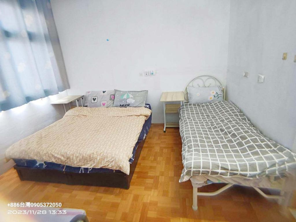 a bedroom with two beds and a wooden floor at 金門瑜仙-住宿租機車-接機免費 in Jinhu