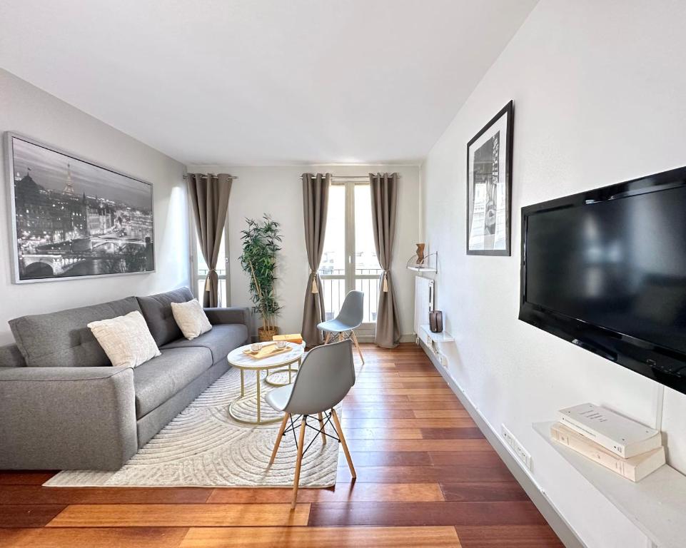 een woonkamer met een bank en een flatscreen-tv bij 1622 - Calm studio in Le Marais Olympic Games 2024 in Parijs