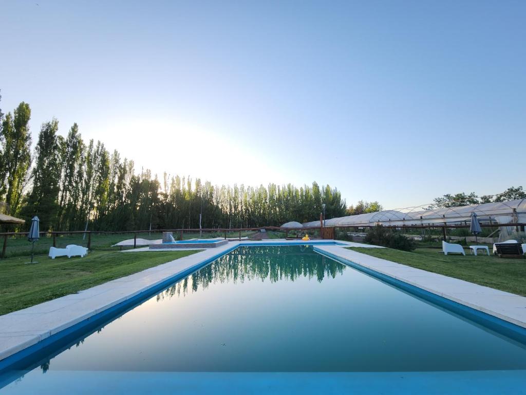 a swimming pool with blue water in a yard at Casa de Campo Flor Dorada in Centenario