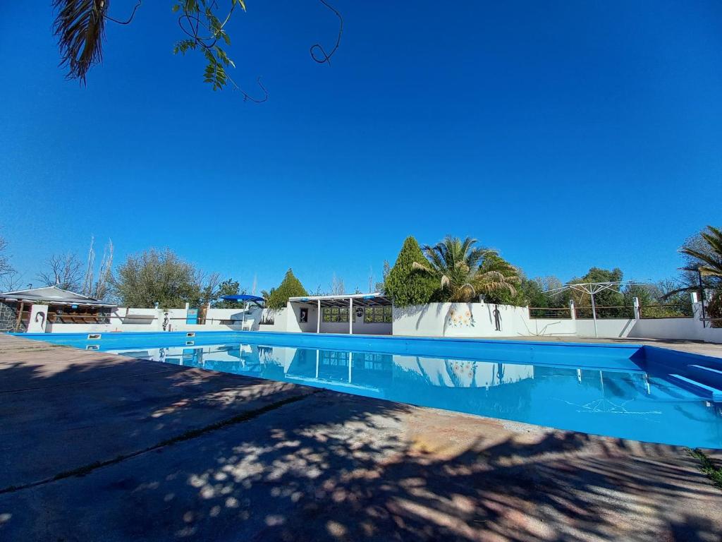 una piscina azul con un cielo azul en el fondo en Cabañas La Horqueta en San Rafael