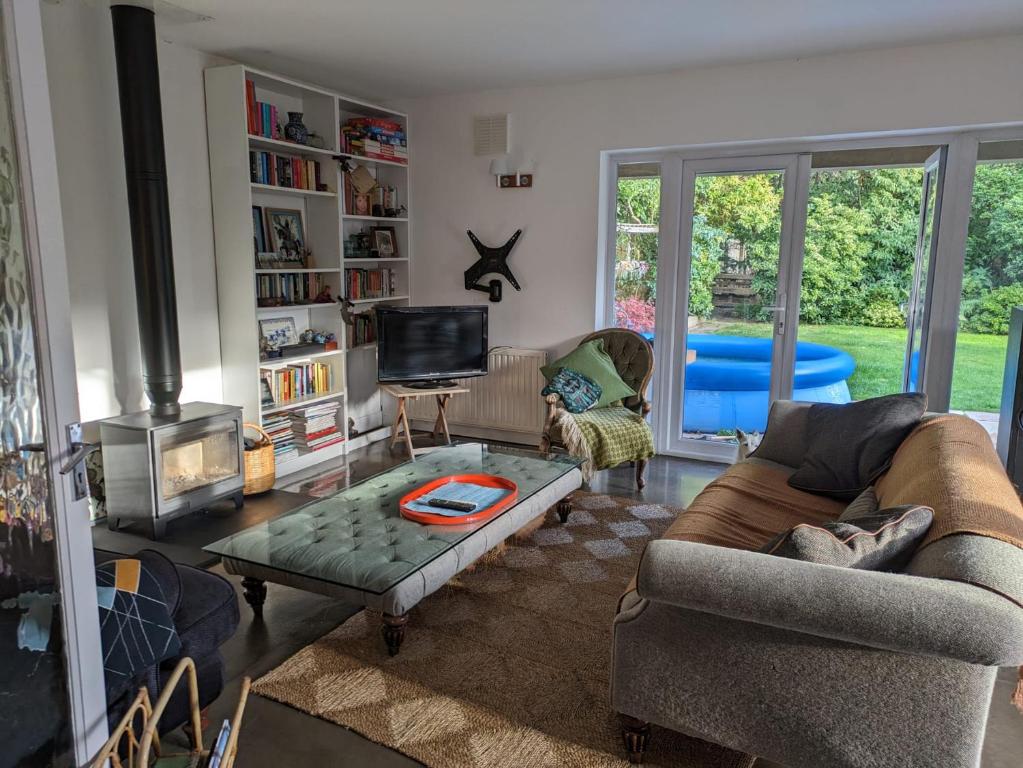 uma sala de estar com um sofá e uma mesa em Cosy Garden View Room em East Grinstead