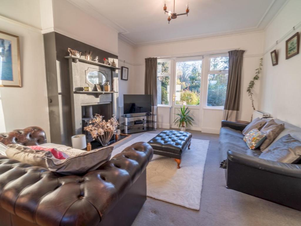 a living room with leather furniture and a fireplace at Pass the Keys Gorgeous 5 bedroom home in Nottingham