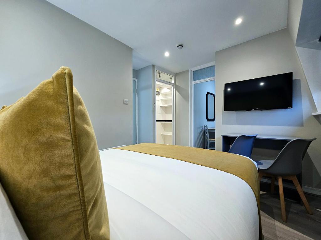 a hotel room with a bed and a tv at BOKA Earls Court in London