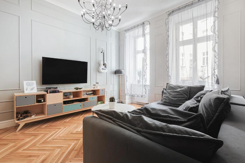 sala de estar con sofá y TV de pantalla plana en Klimatyczny apartament w centrum, en Wroclaw