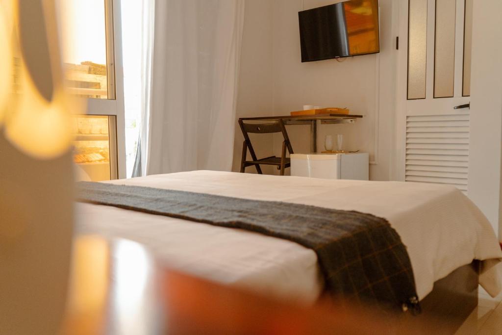 a bedroom with a bed and a television on the wall at Bela Sombra in Vila da Ribeira Brava