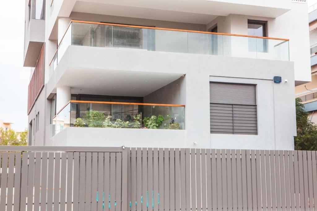a white house with a fence in front of it at Voula Luxury Apartment in Athens