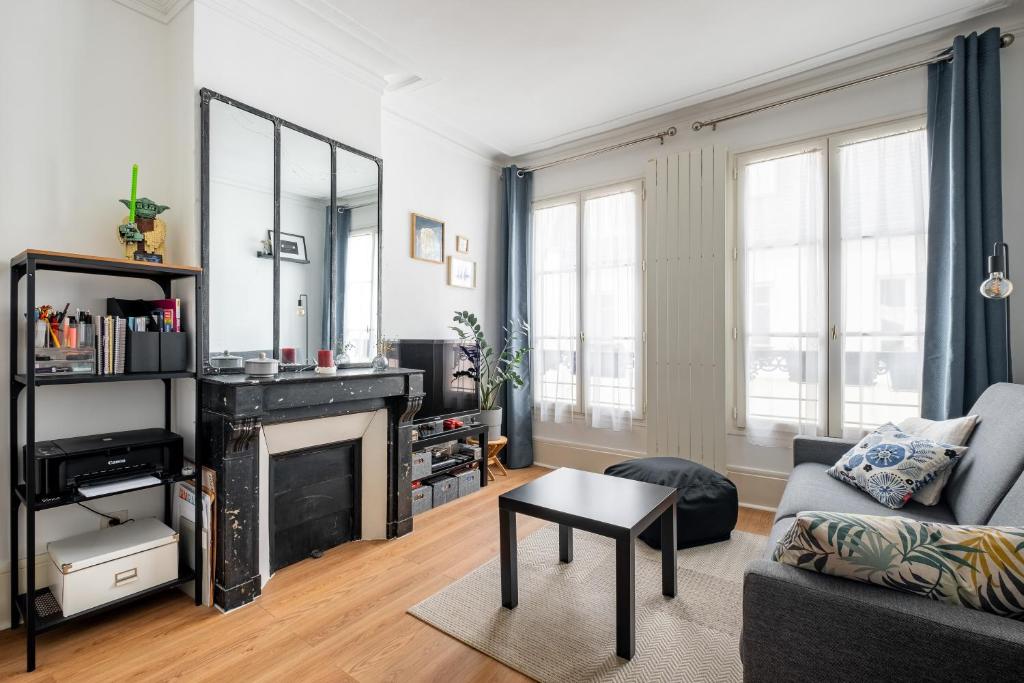 un salon avec un canapé et une cheminée dans l'établissement Veeve - Batignolles Blues, à Paris