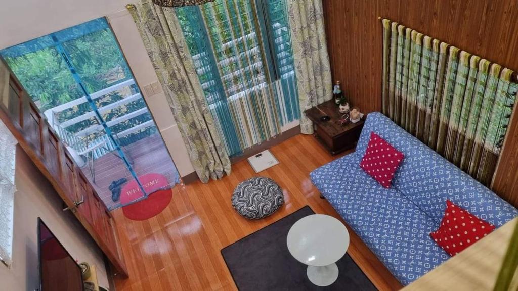 sala de estar con sofá azul y almohadas rojas en Cozy TinyHouse near SM & Bagasbas Beach w/parking, en Daet