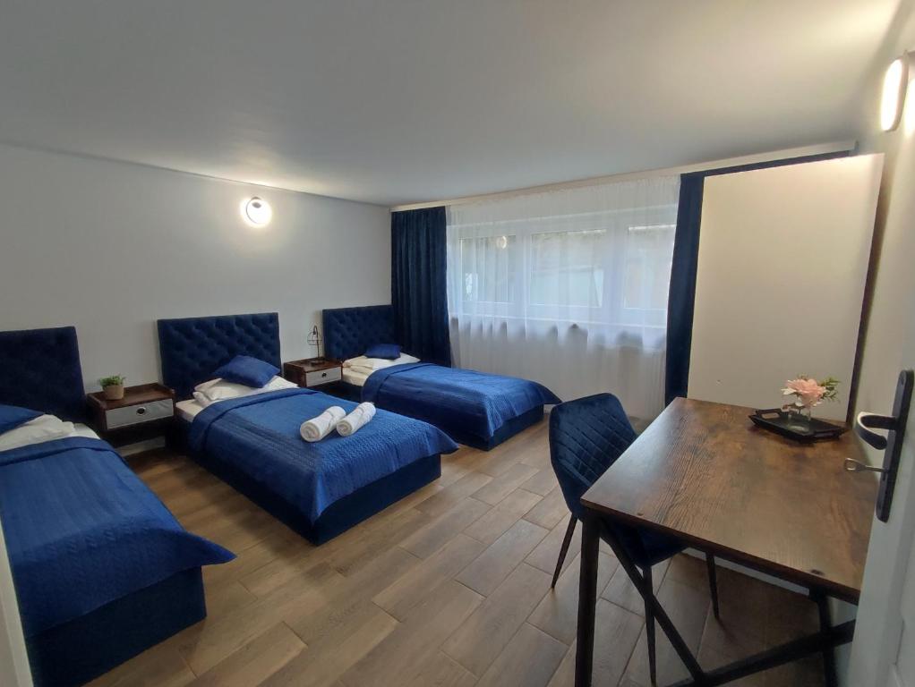 ein Hotelzimmer mit 2 Betten und einem Tisch in der Unterkunft Apartament LoftyDream in Mielec