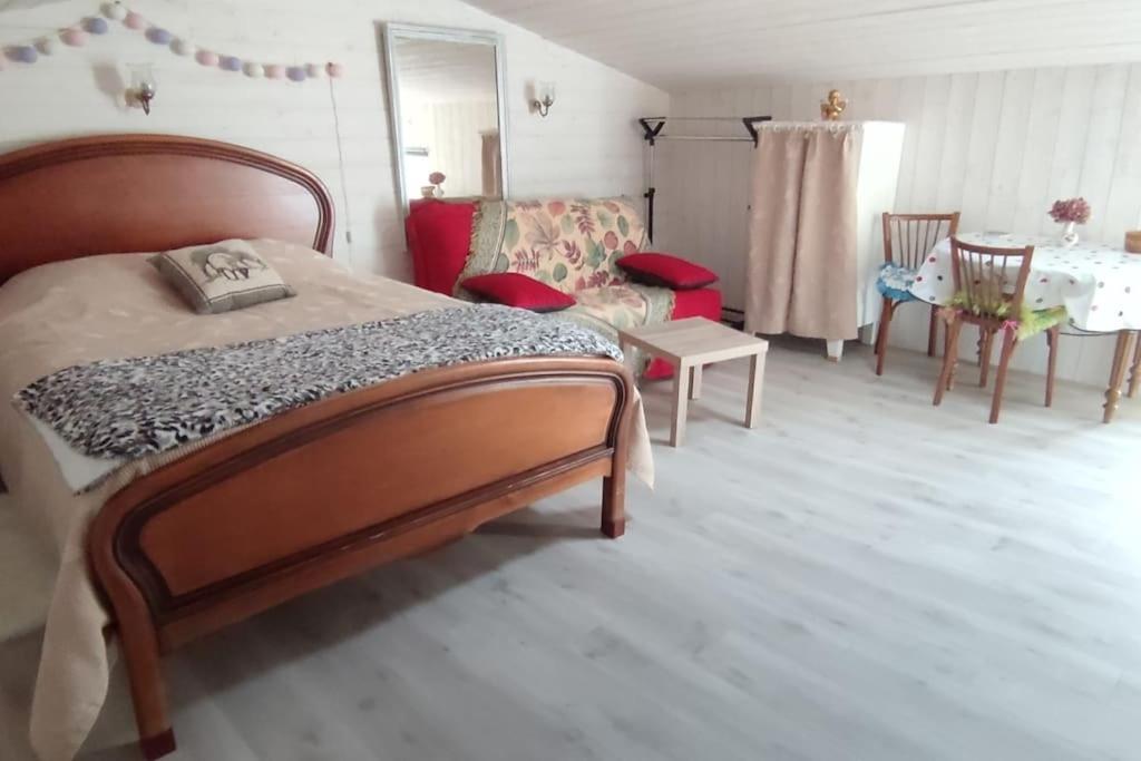 um quarto com uma cama, uma mesa e cadeiras em Studio Propre et Cosy em Le Mesnil-en-Vallée