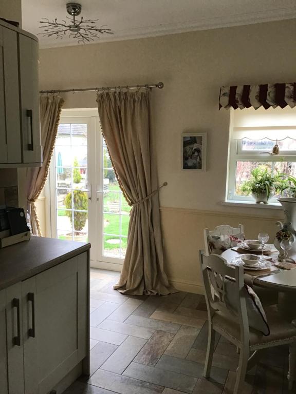 a kitchen with a table and chairs and a window at The Miners Cottage in Blackwood