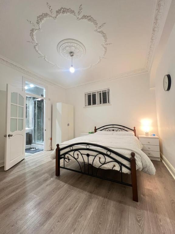 um quarto branco com uma cama e um tecto branco em StayEasy En-Suite London em Londres