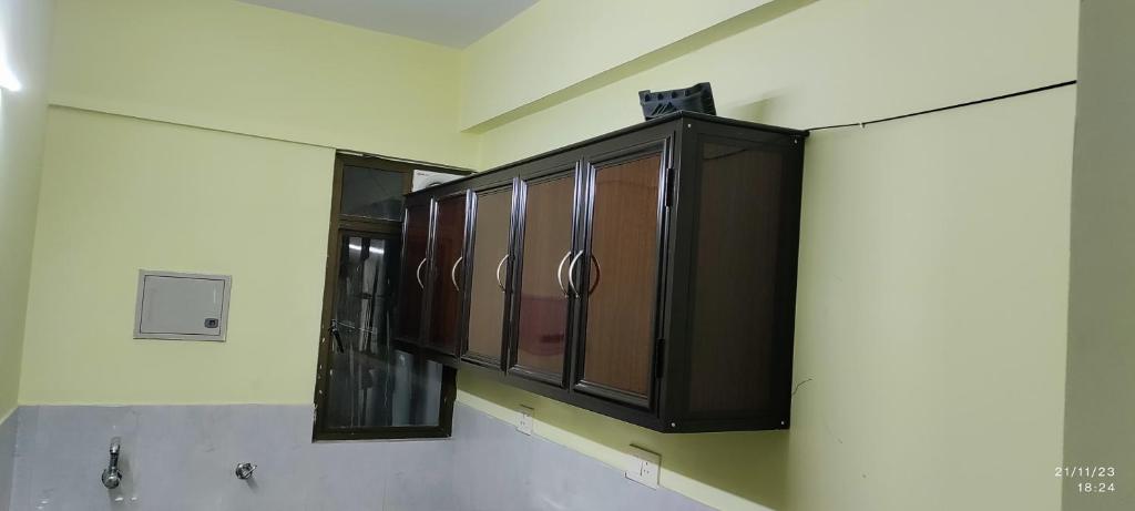 una cucina con armadietti in legno appesi a una parete di 1 BHK Flat in Kochi 904 a Cochin