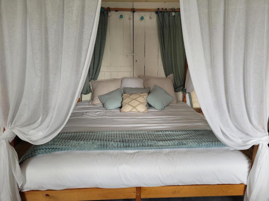una cama con cortinas en una habitación en Chambre Océan Cosy Bordeaux Saint Emilion, en Le Gabaron