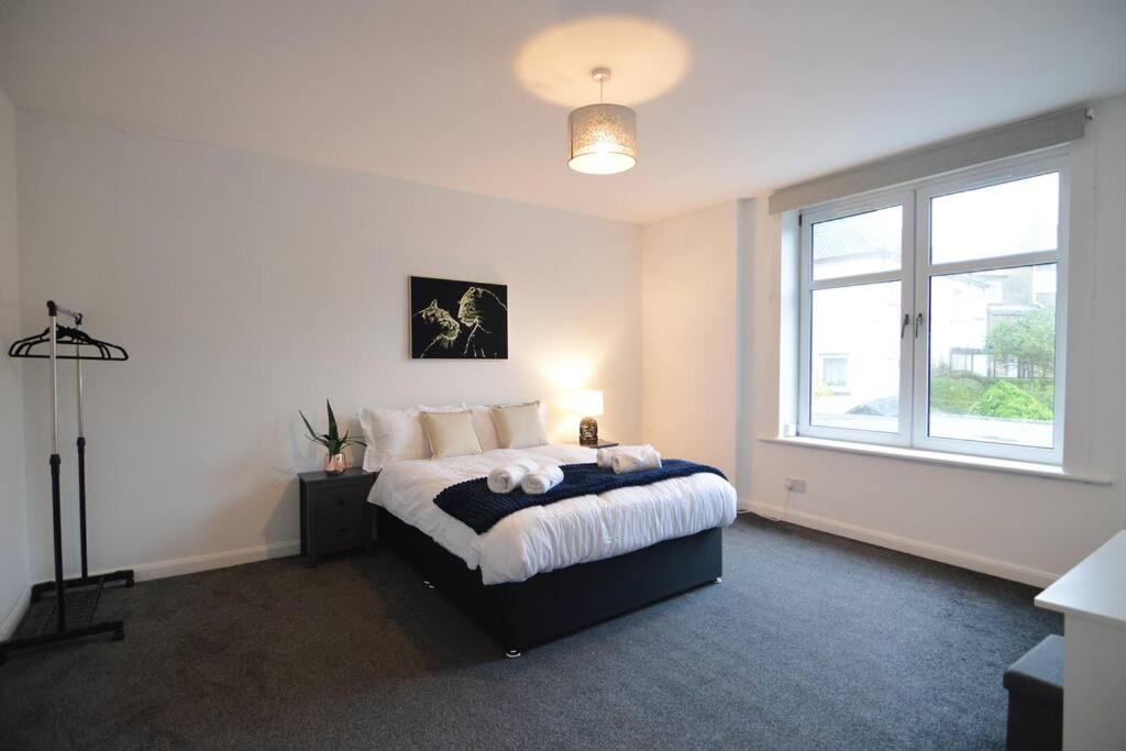 a bedroom with a bed and a large window at Contemporary 3 Bedroom Flat in Fife
