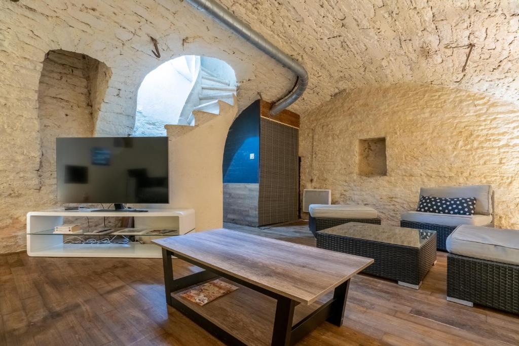 un salon avec une table et un canapé dans l'établissement Le Crébillon d'Or - Joli cocon dijonnais, à Dijon