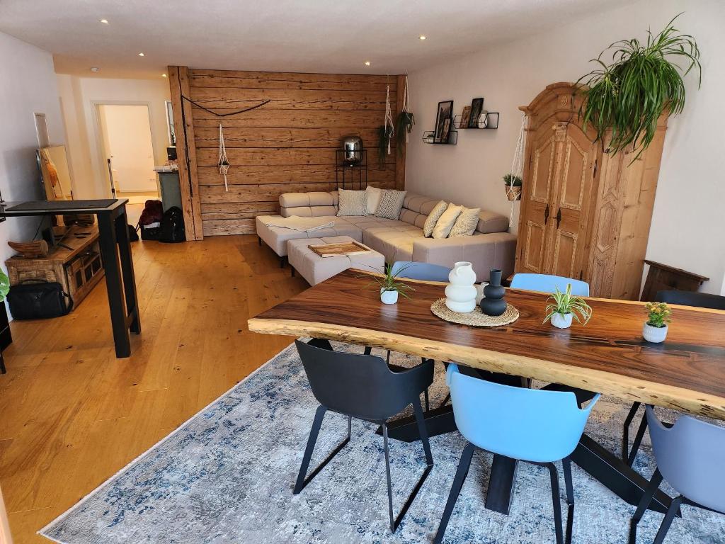 uma sala de estar com uma mesa de madeira e cadeiras azuis em Exclusive 120 qm Wohnung am Wössner em Unterwössen