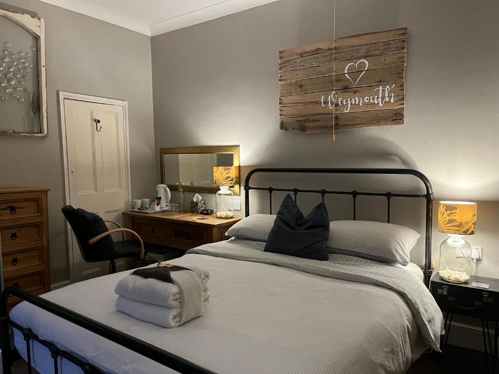 a bedroom with a bed with a mirror and a sink at Kelston Guest House in Weymouth