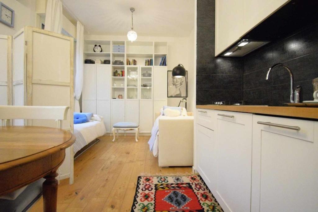 卡斯泰纳索Piccolo Angolo in Città的带白色橱柜的厨房和客厅