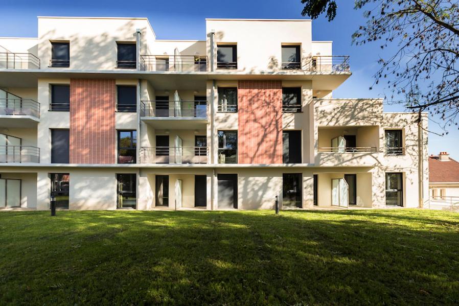 an apartment building with a lawn in front of it at Zenao Appart'Hotel in Nevers