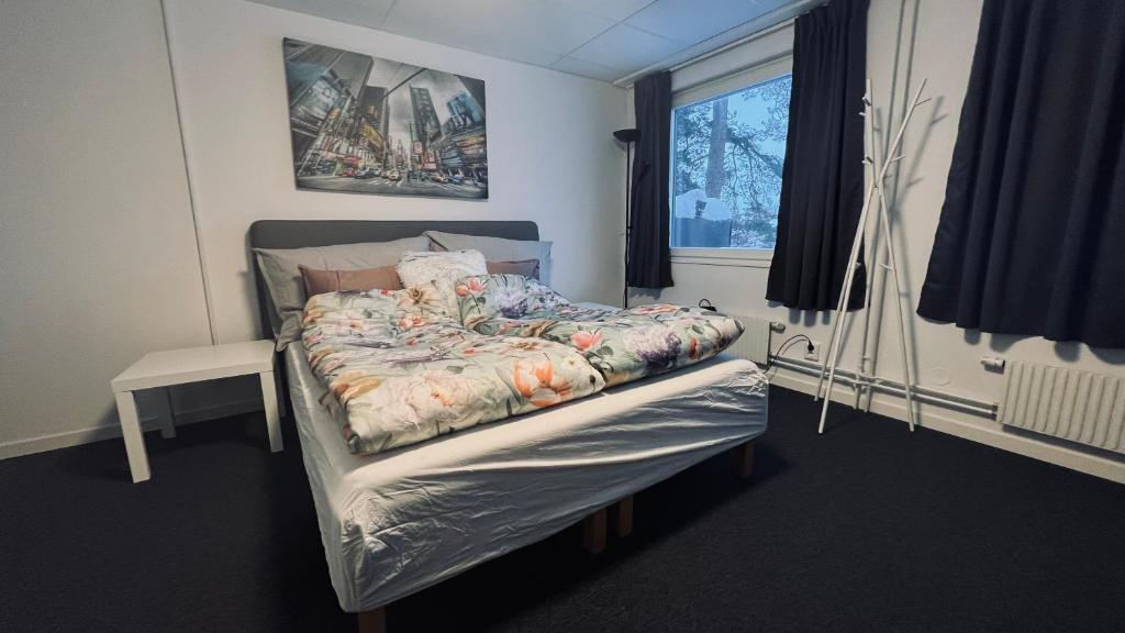 a bedroom with a bed with a comforter and a window at Rentalux Apartments at Vivansborg in Timrå
