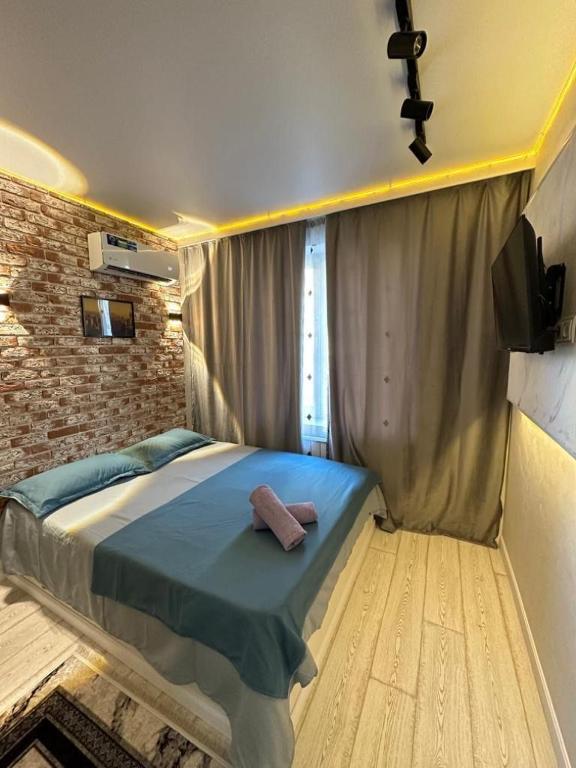 1 dormitorio con cama y pared de ladrillo en Auezov City Almaty, en Almaty