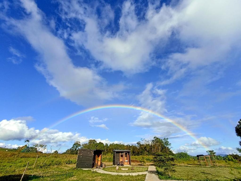 un arc-en-ciel au-dessus d'un champ dans l'établissement Wawowow, à Tomohon