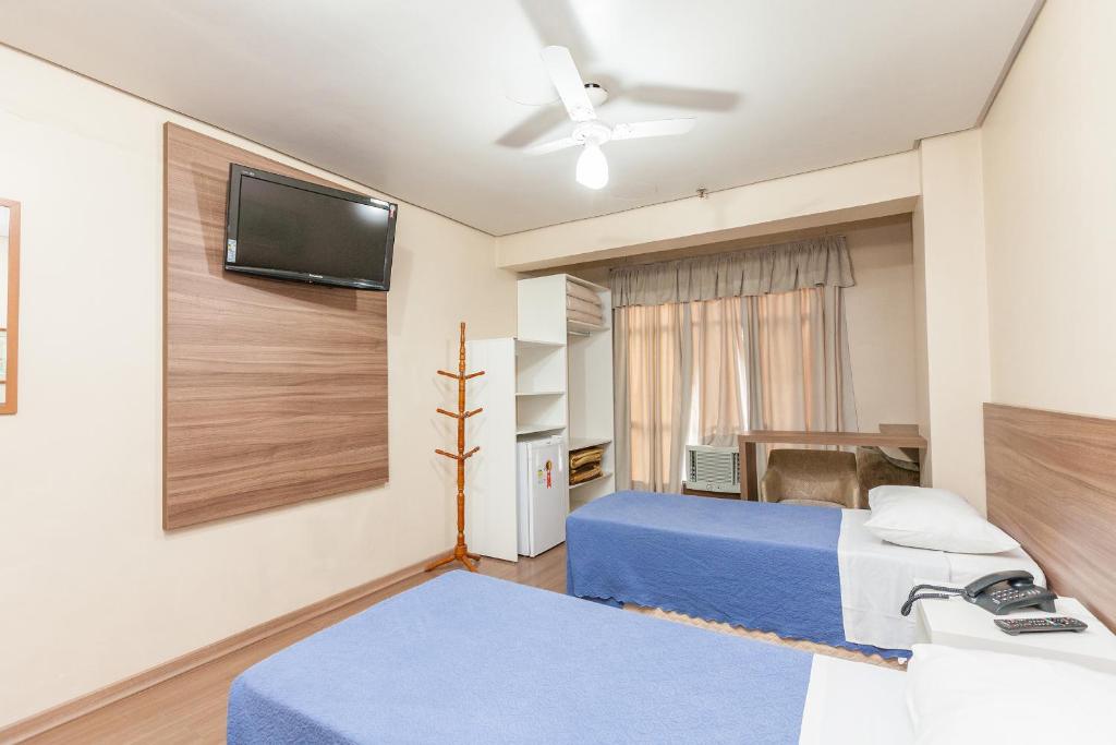 1 dormitorio con 2 camas y TV de pantalla plana en Letto Hotel Porto Alegre, en Porto Alegre