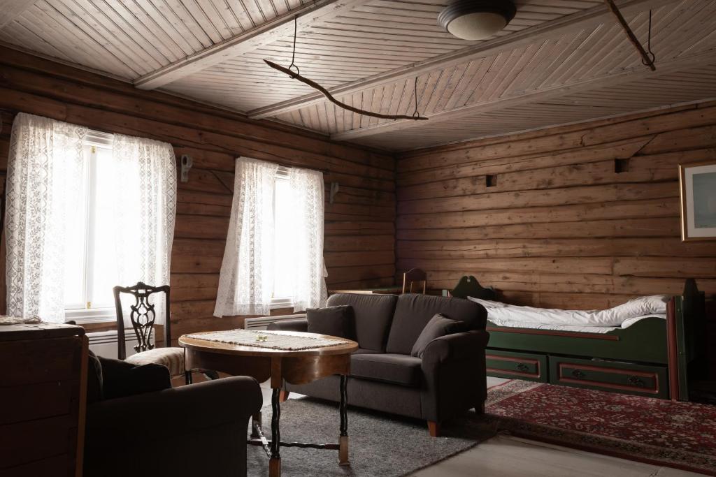 a living room with wooden walls and a bed at Bergmannsgata 3 in Røros
