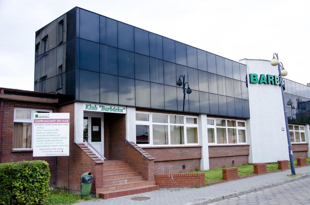 a large building with a sign on the side of it at Hostel Barbórka in Turek