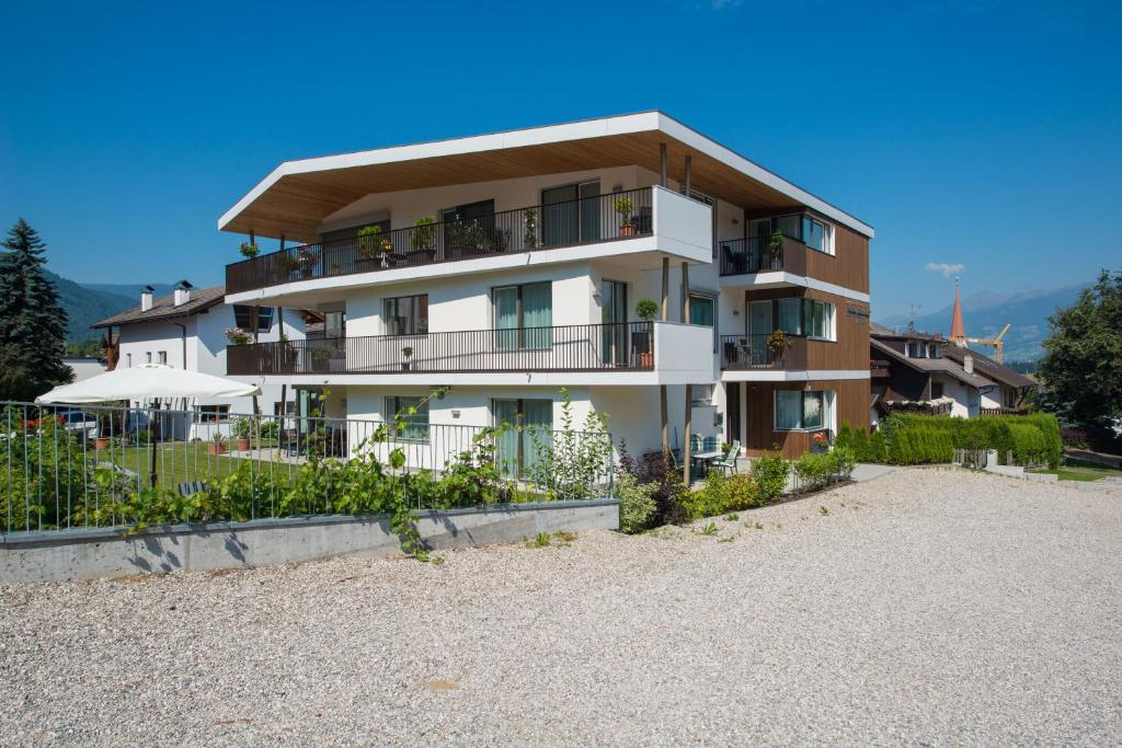 - un grand bâtiment blanc sur la plage à côté d'un bâtiment dans l'établissement Apartment Edelweiss, à Brunico