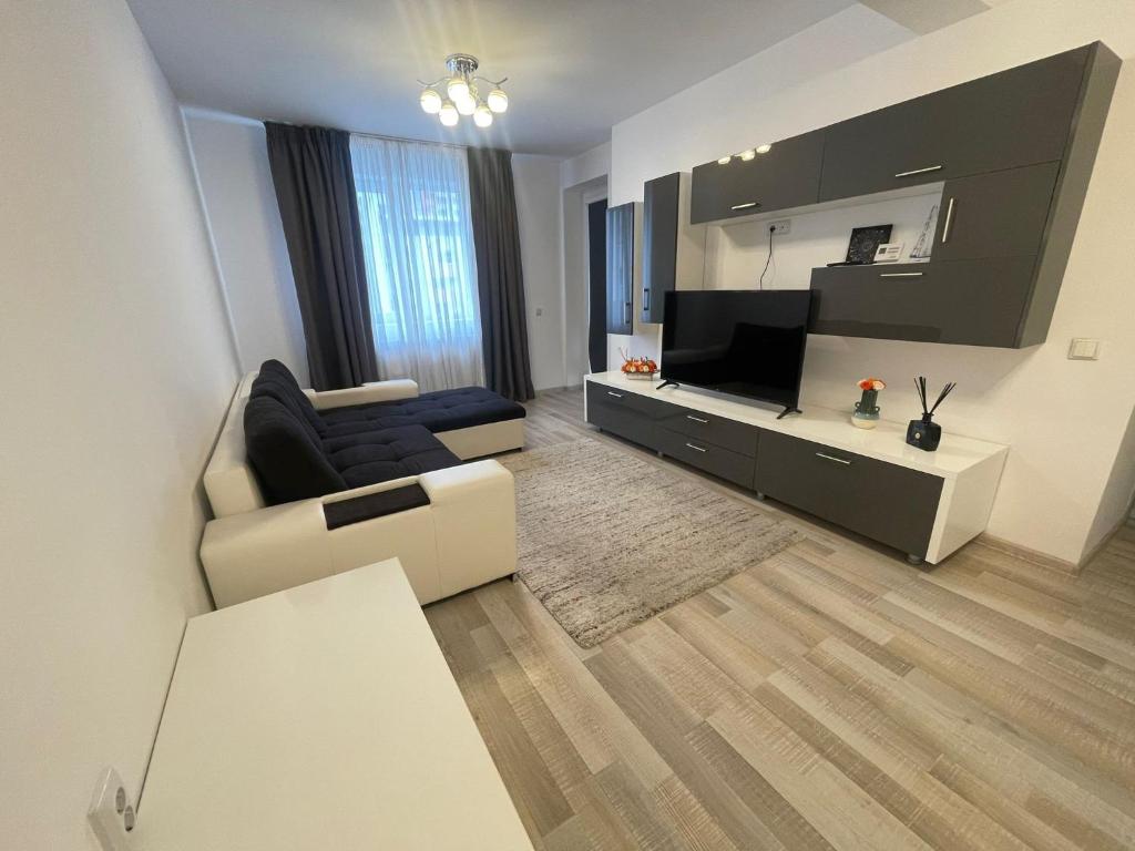 a living room with a couch and a television at Coresi Mall Relax apartment in Braşov