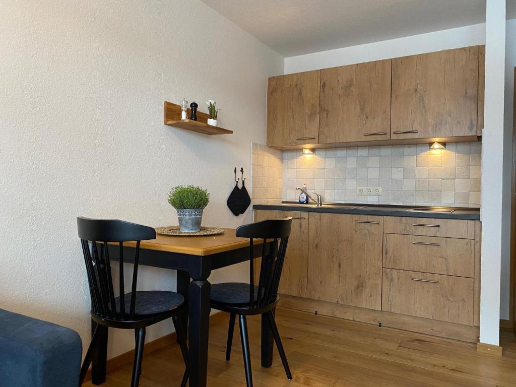 a small kitchen with a table and two chairs at Almstube in Bad Hindelang