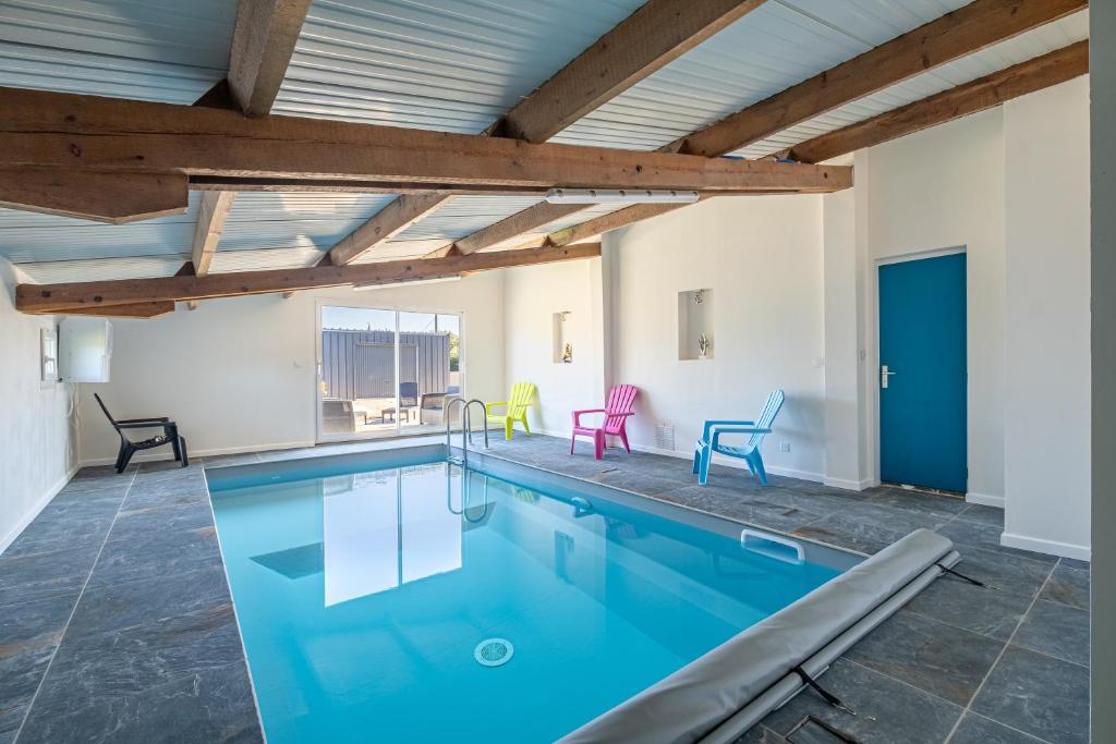 una piscina cubierta de agua azul en un edificio en Le Cottage de Flore - Avec piscine privée chauffée en Saint-Jean-la-Poterie