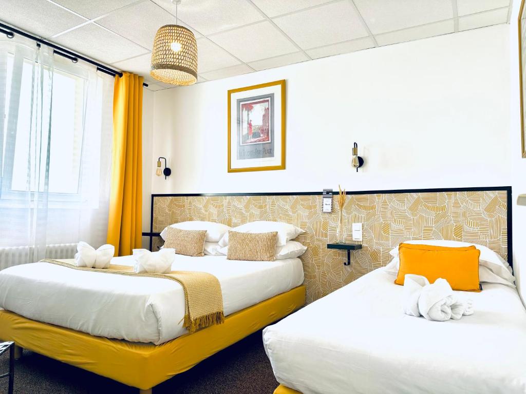 two beds in a hotel room with yellow curtains at Hôtel Gaspard in Le Touquet-Paris-Plage