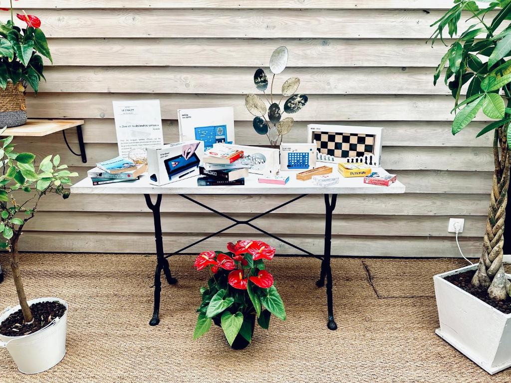 a table with a laptop on it next to plants at Hôtel Gaspard in Le Touquet-Paris-Plage