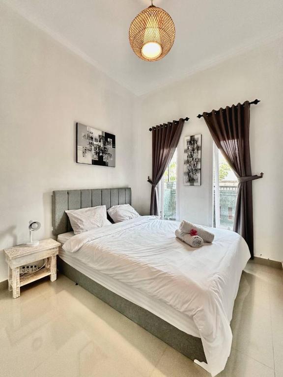 - un grand lit blanc dans une chambre avec fenêtre dans l'établissement Guest house Star No.1, à Bedahulu