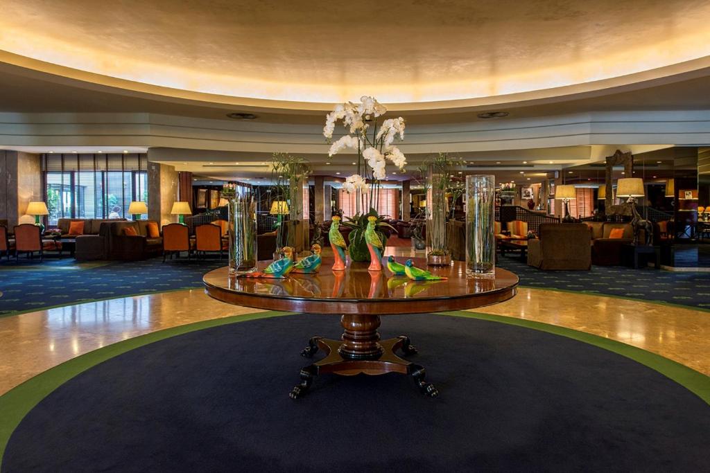 a lobby with a table with vases on it at Hotel Solverde Spa and Wellness Center in Vila Nova de Gaia