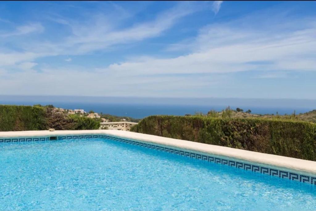 een zwembad met de oceaan op de achtergrond bij Apartamento Coral in Denia